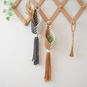 Detail of bohemian macrame wall hanging baskets with wood rings and cotton rope fringe