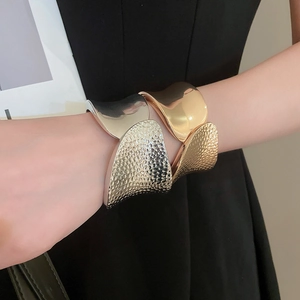 Detailed close-up showing textured hammered metal cuffs in gold and silver finishes