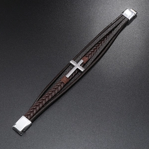 Diagonal close-up of multilayer braided leather bracelet with silver cross and magnetic clasp