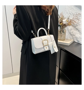 White faux crocodile leather crossbody bag shown on black coat with mini coin purse detail
