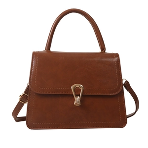 Vintage brown faux leather crossbody bag with metallic lock and top handle on white background