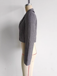 Détail de la texture pied-de-poule et de la taille ajustée de ce blazer court