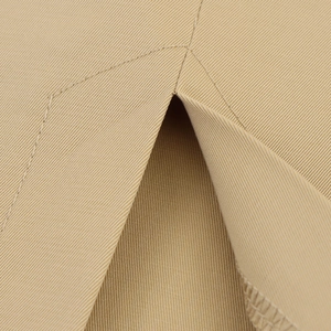 Close-up of khaki twill fabric texture and refined split seam detail on an elegant dress