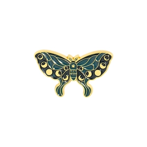 Detail of vintage enamel butterfly brooch with celestial moon phase and gold metal accents
