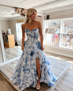Detail of blue and white floral evening dress showing corset waist and ruffled slit hem