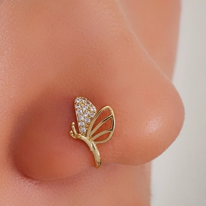 Close-up of golden U-shaped butterfly nose clip with zircons on model's face