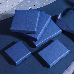 Macro detail of royal blue jewelry boxes with cross-grain texture and elegant ribbons