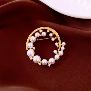 Elegant 24k gold plated round brooch with pearls and crystals on velvet fabric