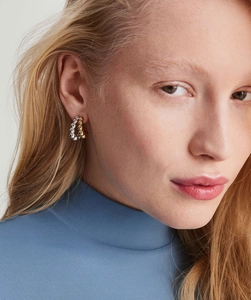 Detail of two-tone gold and silver C-shaped bubble bead earrings on a model profile