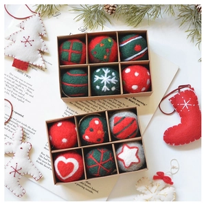 Detailed view of handmade Christmas wool felt ball ornaments with stars and trees