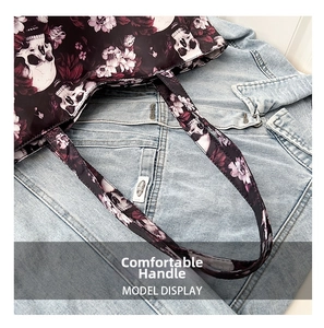 Close-up of comfortable tote handle featuring gothic skull and purple floral print pattern