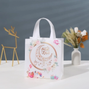 Detail of white Eid Mubarak gift bag featuring golden moon and floral patterns