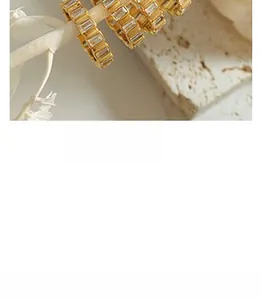 Close-up of gold titanium steel ring with sparkling baguette-cut cubic zirconia inlays