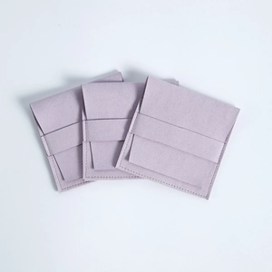 Three light purple microfiber jewelry pouches with flap closure on white background