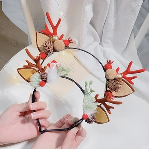 Christmas reindeer antler headband with brown cones, red berries and Santa doll