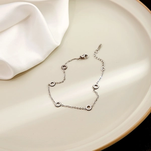 Detail shot of silver geometric gear charm bracelet with adjustable lobster clasp