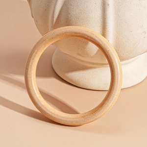 Macro detail of natural wood grain texture on a minimalist geometric open bangle bracelet
