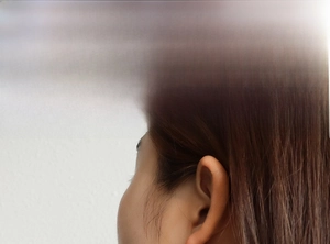 Detailed model shot showing elegant 18K gold-plated safety pin earrings on ear