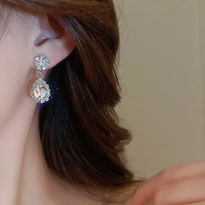 Detailed close-up of an elegant silver-toned teardrop earring with sparkling crystals