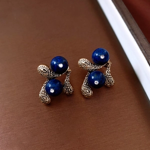 Detailed close-up of vintage resin water drop earrings with blue stones and crystals