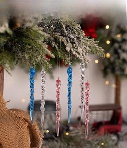 Pink and blue spiral acrylic icicle ornaments hanging on a snowy Christmas tree