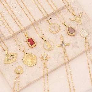 Golden stainless steel pendant necklaces with owl, heart and sun charms on stone