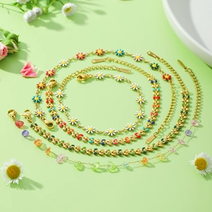 Bracelets de cheville en acier doré avec marguerites colorées et perles sur fond floral