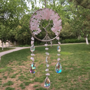 Detail of pink crystal Tree of Life suncatcher with faceted prisms in a garden setting
