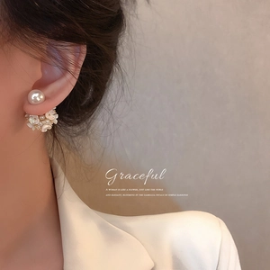 Elegant camellia flower earrings with pearls shown in a close-up on a female model