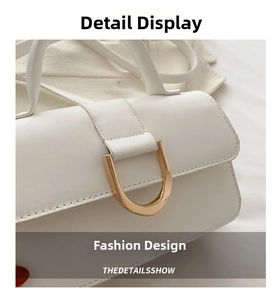 Detail shot of elegant white leather crossbody bag featuring a golden D-shaped buckle