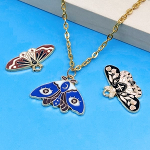 Detail of colorful enamel butterfly pendants with mystic motifs on gold chain necklace