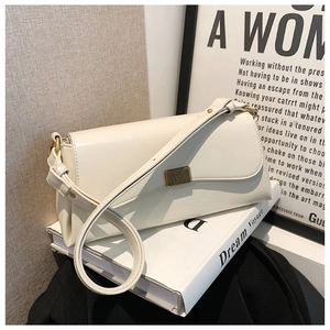 Detail einer weißen Leder-Schultertasche mit elegantem goldenem Rechteck-Drehverschluss