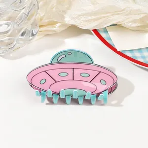 Detailed close-up of a pink and green UFO shaped acrylic hair claw clip with glossy finish
