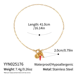 Détail du collier en acier doré avec pendentifs piment, poisson, coquillage et mesures