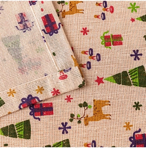 Close-up of Christmas linen tablecloth fabric featuring reindeer and festive patterns
