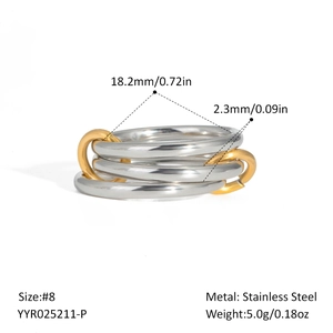 Macro detail of triple silver-tone stainless steel bands linked by two golden rings