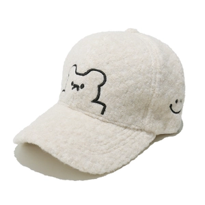 Detail of cream bouclé fleece baseball cap with teddy bear and smiley face embroidery
