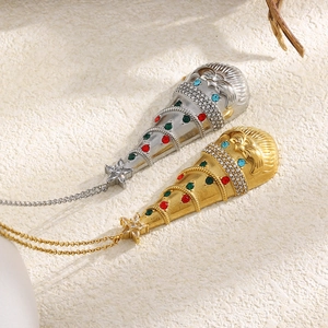 Gros plan de pendentifs bonnet de Noël dorés et argentés avec des strass multicolores