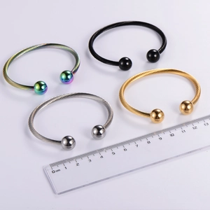 Macro detail of four-color cable textured bracelets with scale showing 6cm diameter