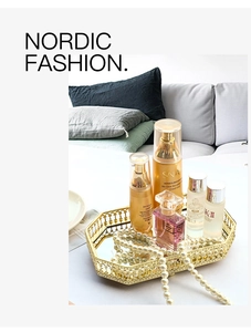 Octagonal gold metal mirror tray holding cosmetics and jewelry in a modern setting