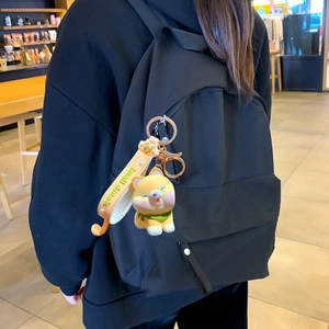 Süßer Shiba Inu Schlüsselanhänger mit grünem Schal und orangefarbenem Band am Rucksack