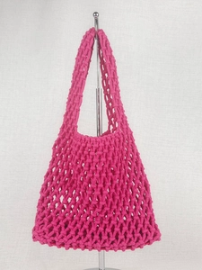 Minimalist hand-woven cotton mesh beach bag in vibrant rose red with sturdy handles