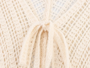 Detail shot of the beige hollow out knit fabric texture and the front drawstring closure