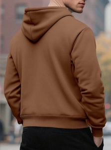 Back view of a deep brown hoodie featuring ribbed hem and cuffs in an urban street setting