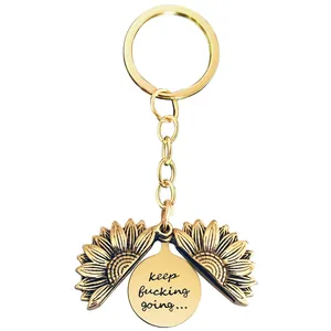 Detailed close-up of a metal sunflower keychain with an opening locket and engraved quote