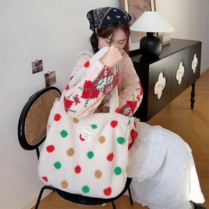 Detailed shot of plush tote bag featuring colorful polka dots held in a cozy indoor setting