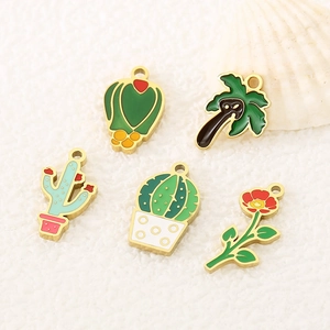 Detailed view of colorful enamel cactus and palm tree pendants with gold metal frames