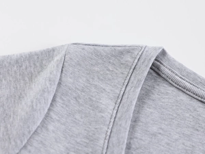 Close-up of the double-stitched shoulder seam and neckline on a gray knitted tee