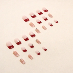 Faux ongles rouge vin et nude avec perles, strass et décorations pailletées dorées