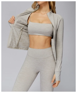 Detailed layered look of 3-piece gray athletic set featuring zip jacket and high-waist yoga pants
